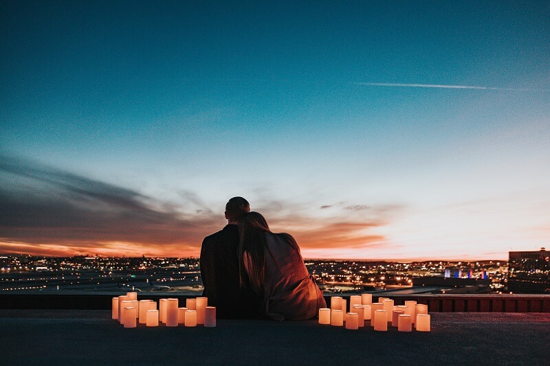 couple sitting in front of the horizon in the evening with candlelight
