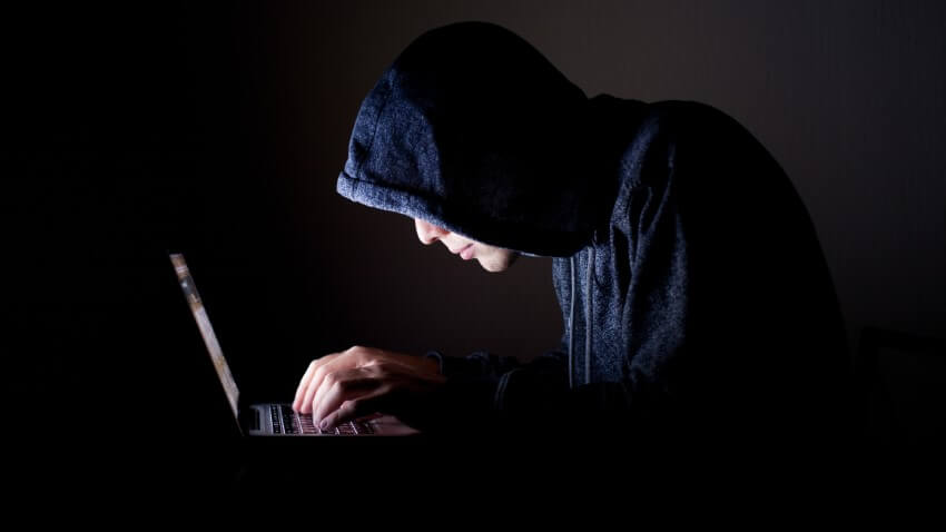 hacker on his laptop tries to scam online daters