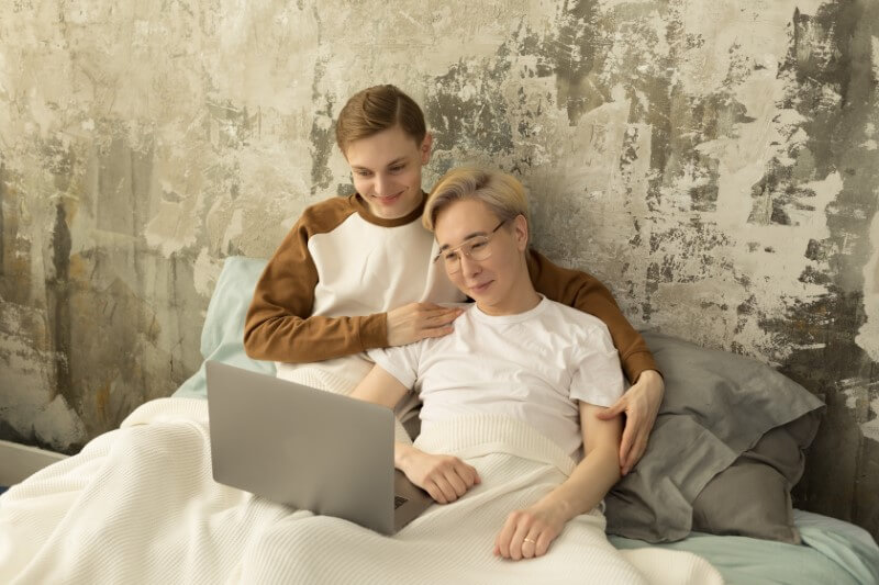 gay couple watching movies in bed