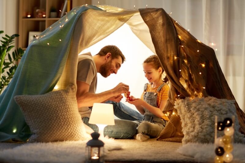 single dad has tea party with his daughter in a selfmade tent
