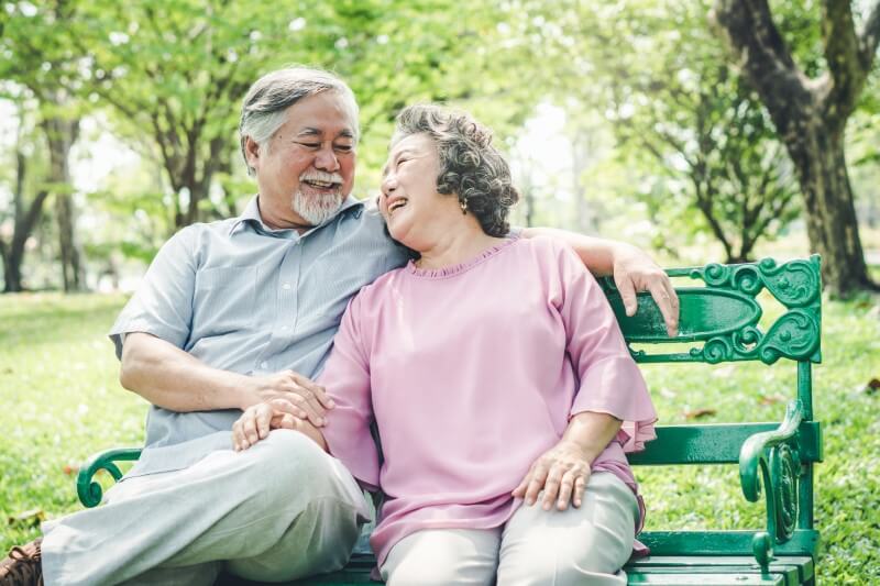 elderly asian couple hold hands in the park