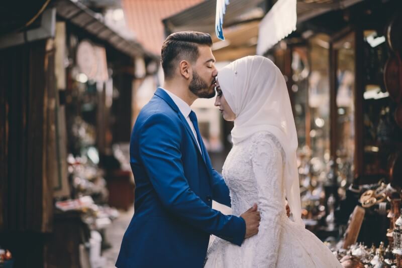 newly-wed muslim husband kisses his wife on crown of her head