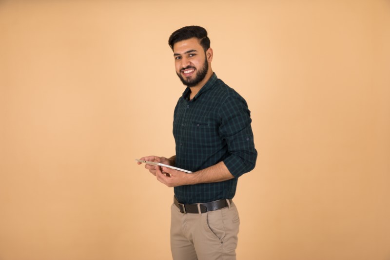 handsome muslim man holds tablet device